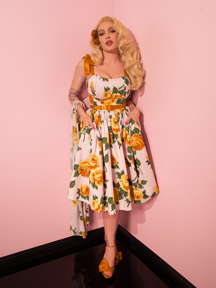 Micheline Pitt, adorned in the 1950s Swing Sundress and Scarf in Yellow Vintage Roses from Vixen Clothing, gracefully displays an array of poses during her modeling session.