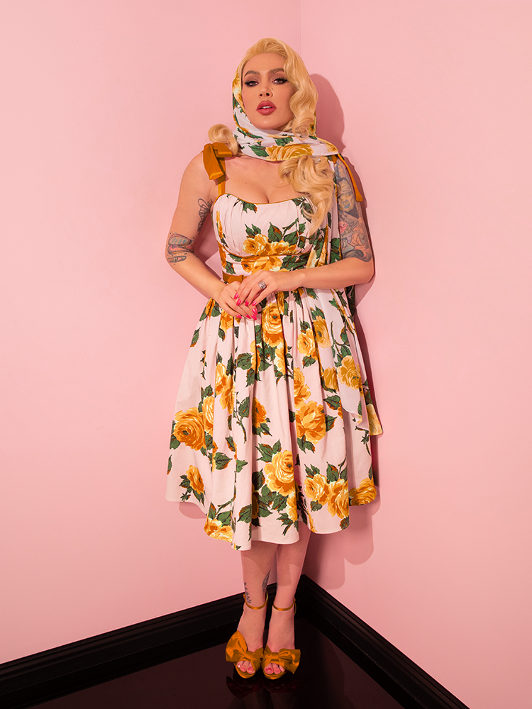 Modeling the 1950s Swing Sundress and Scarf in Yellow Vintage Roses from Vixen Clothing, Micheline Pitt captivates with a variety of poses.