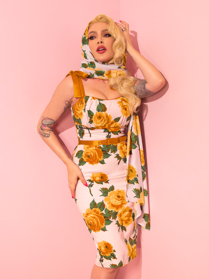 Micheline Pitt showcases a range of poses as she models the 1950s Wiggle Sundress and Scarf in Yellow Vintage Roses from the retro apparel label Vixen Clothing.