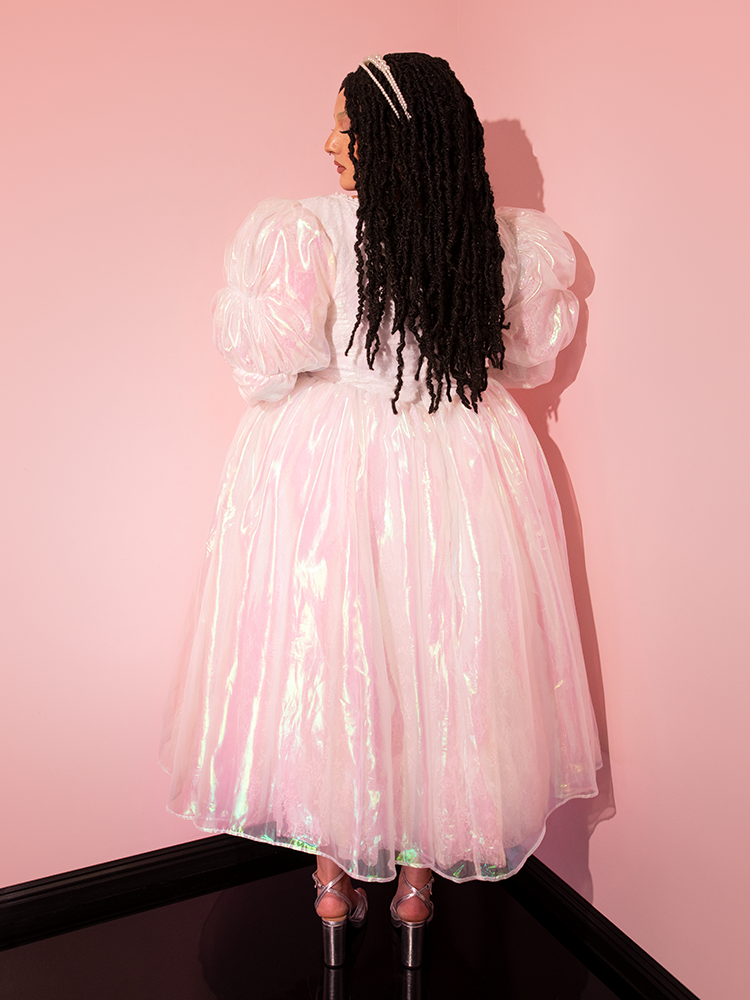 Embrace the enchanting nostalgia of the LABYRINTH™ Sarah Goblin Ball Gown in Pearlescent White, as a captivating mannequin brings to life the retro splendor curated by Vixen Clothing, the ultimate vintage destination.