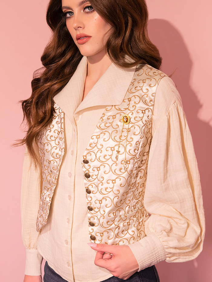 A stunning brunette model effortlessly wears the LABYRINTH™ Sarah Vest, complete with a matching Amber Brooch, courtesy of Vixen Clothing's vintage-inspired collection.