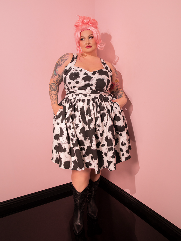 Transporting you back in time, the enchanting female model effortlessly displays the retro charm of the Vixen Skater Skirt in Cow Print, a must-have piece from the iconic brand, Vixen Clothing.