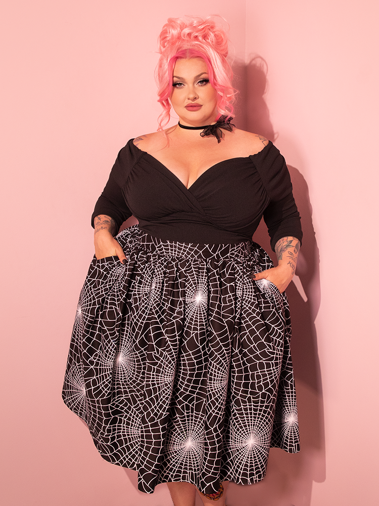 Radiant retro diva striking a pose in the recently launched Vixen Swing Skirt adorned in the enchanting Black Spider Web Print, a timeless creation from Vixen Clothing – the ultimate name in vintage elegance.