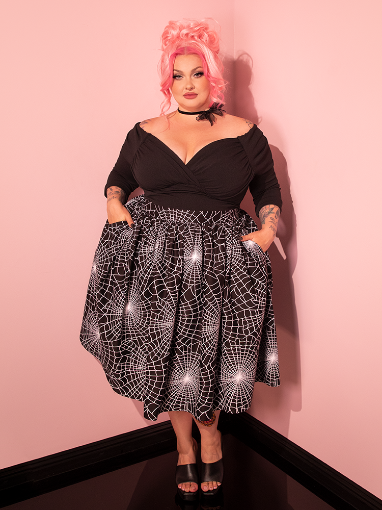 An exquisite retro siren strikes a pose in the brand-new Vixen Swing Skirt, adorned with the captivating Black Spider Web Print, a true testament to Vixen Clothing's vintage legacy.