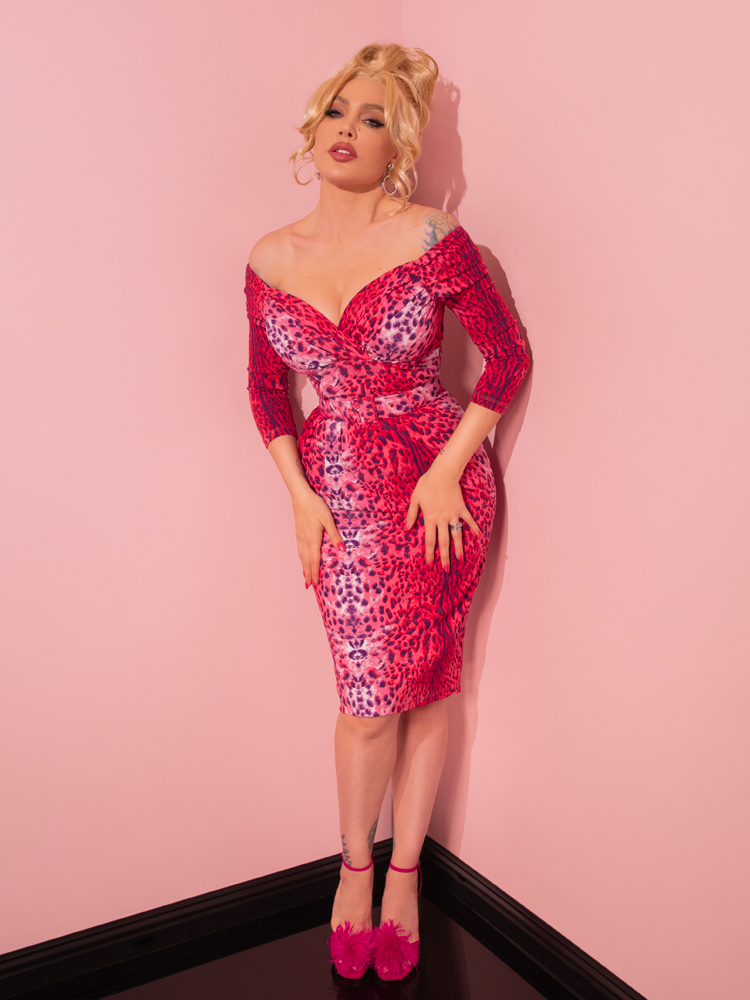 Prepare to be enamored by a stunning model radiating vintage grace while wearing the Pink Leopard Print Starlet Wiggle Dress and Scarf, a true gem from Vixen Clothing's retro assortment.