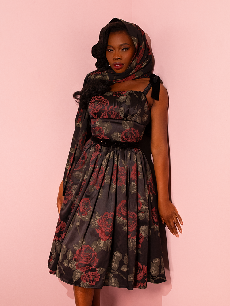 Step back in time with the allure of Vixen Clothing's 1950s Satin Swing Sundress and Scarf in Black Vintage Roses. Experience the vintage charm as models showcase this retro gem with grace and sophistication.