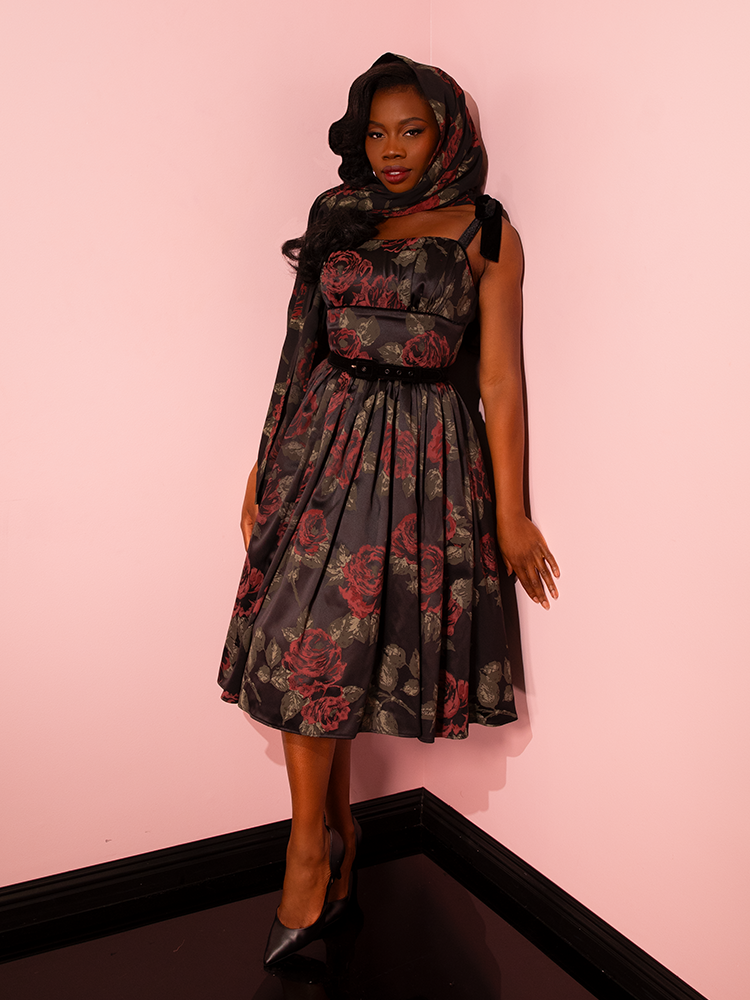 Witness the magic of the 1950s with Vixen Clothing's Satin Swing Sundress and Scarf in Black Vintage Roses. Admire the vintage models as they grace the stage, embodying the elegance of this timeless retro ensemble.