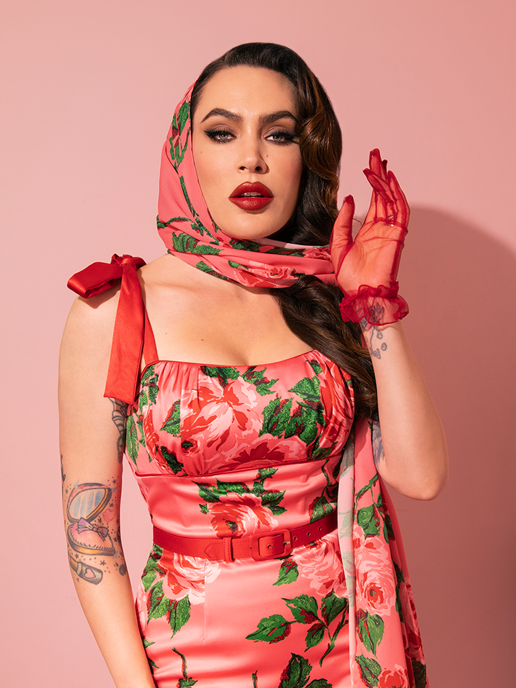 Showcasing sophistication, the beautiful model wears Vixen Clothing's 1950s Satin Wiggle Sundress and Scarf in Pink Vintage Roses, epitomizing retro chic.