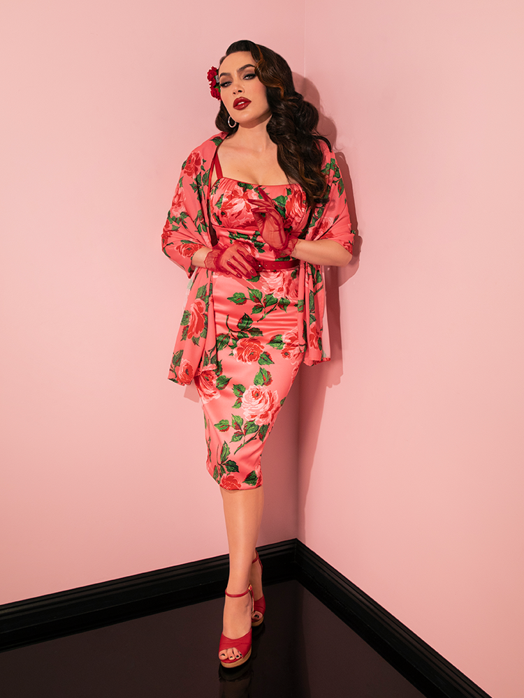 In classic Pink Vintage Roses, the 1950s Satin Wiggle Sundress and Scarf by Vixen Clothing are impeccably modeled by the retro fashion enthusiast.