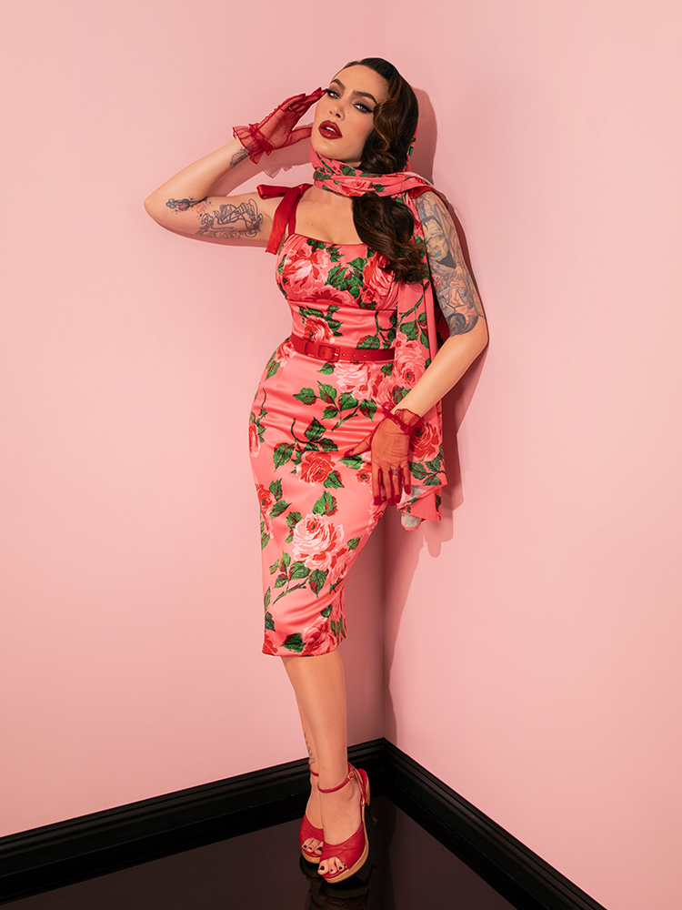 In Pink Vintage Roses, the 1950s Satin Wiggle Sundress and Scarf steal the spotlight, modeled with elegance by the retro fashion icon from Vixen Clothing.