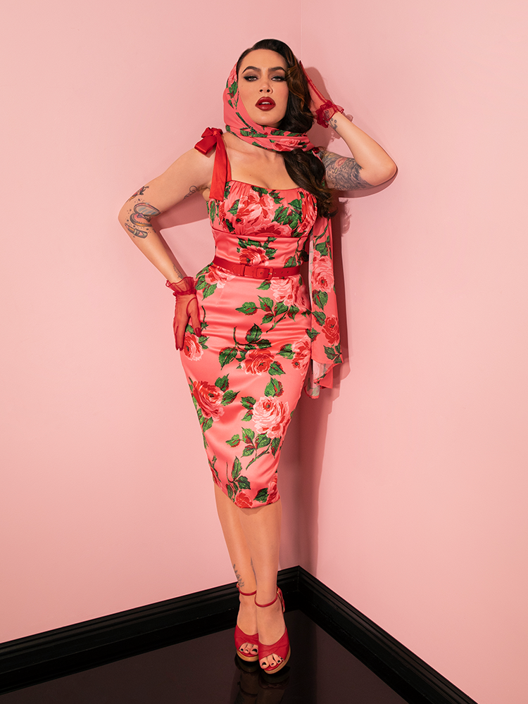 Witness the beauty of vintage fashion as the model showcases the 1950s Satin Wiggle Sundress and Scarf in Pink Vintage Roses by Vixen Clothing.