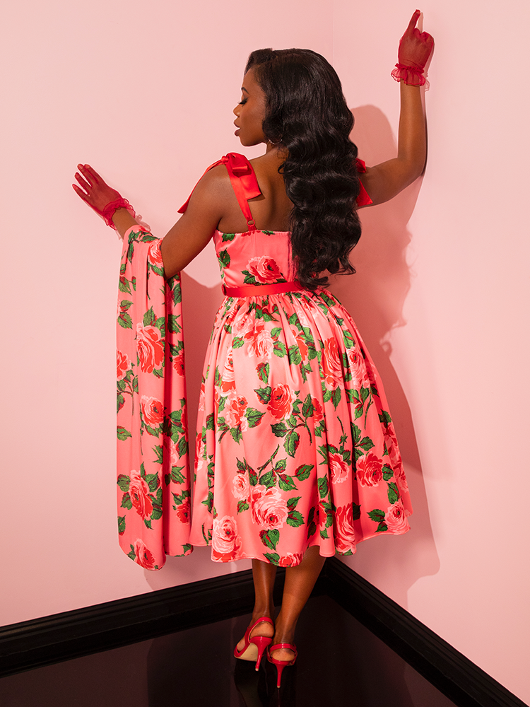 Take a journey through time with Vixen Clothing's 1950s Satin Swing Sundress and Scarf in Pink Vintage Roses. Watch as vintage models captivate the audience, embodying the spirit of a bygone era with style and grace.