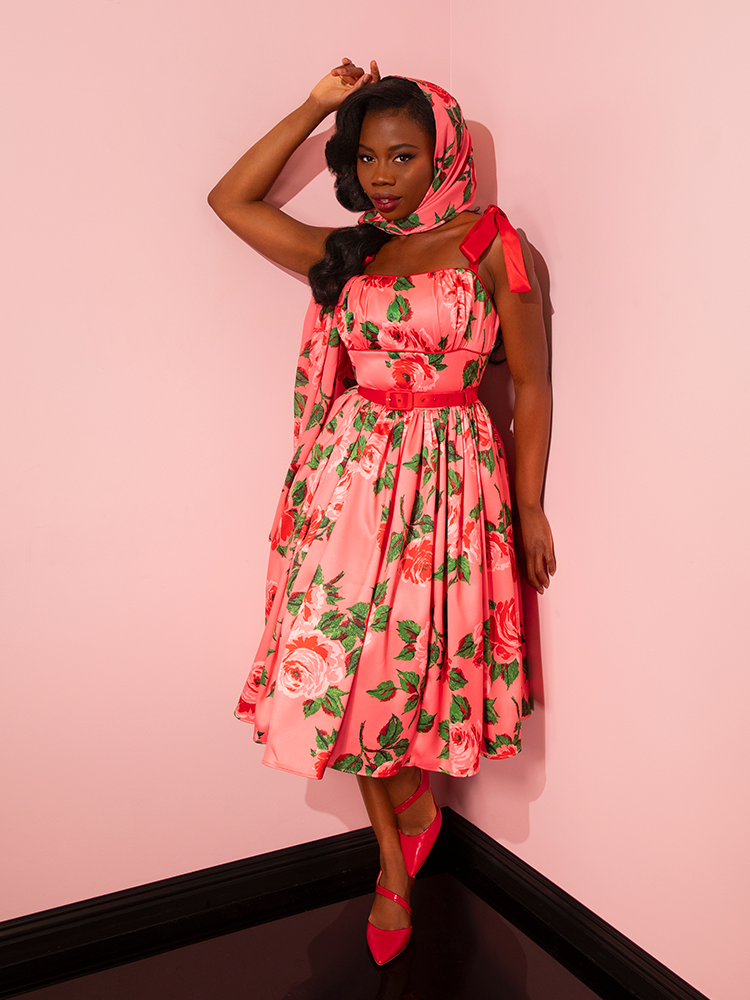 Indulge in the allure of the past with Vixen Clothing's 1950s Satin Swing Sundress and Scarf in Pink Vintage Roses. Witness the charm as it graces the runway, adorned by vintage models exuding elegance.