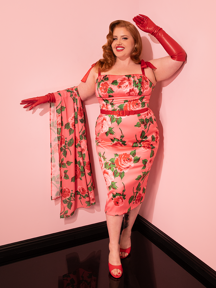The 1950s Satin Wiggle Sundress and Scarf in Pink Vintage Roses becomes a symbol of fun and flirty fashion as female vintage models strike poses, embodying Vixen Clothing's distinctive approach to retro clothing.