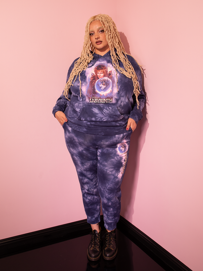Gaze upon the mesmerizing sight of a beautiful model adorned in the retro-chic LABYRINTH™ Goblin King Sweatpants, an enchanting creation in Midnight Blue Tie Dye, hailing from the renowned vintage haven of Vixen Clothing.