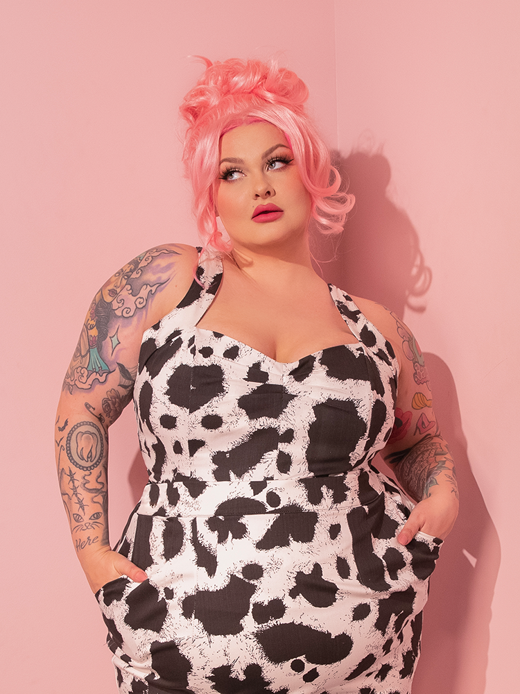 Mesmerizing onlookers with her timeless grace, the stunning femme fatale model effortlessly dons the Vamp Top in Cow Print, a striking creation hailing from the iconic retro clothing brand, Vixen Clothing.
