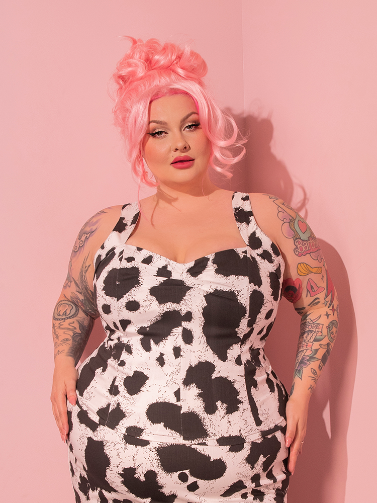 Feast your eyes upon the sight of retro perfection! The utterly captivating female model confidently showcases the Vamp Top in Cow Print, a true treasure from the revered retro clothing brand, Vixen Clothing.