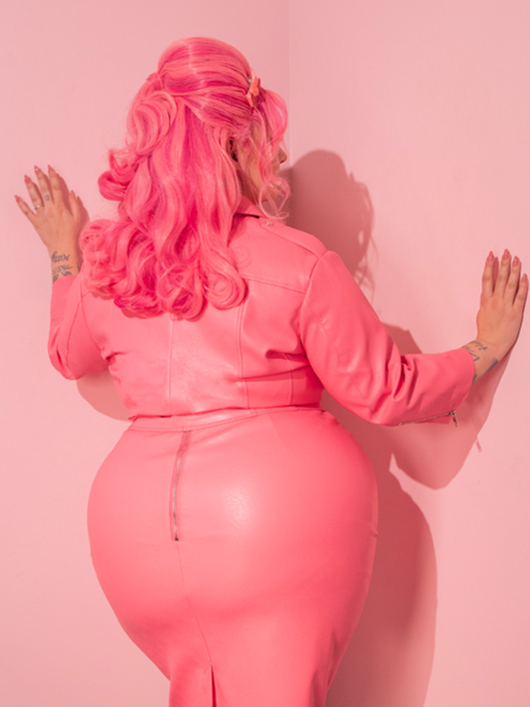 Let the glamorous aura of the stunning model mesmerize you as she dons the all new Bad Girl 3/4 Sleeve Cropped Motorcycle Jacket, a stunning creation in Flamingo Pink Vegan Leather from Vixen Clothing, a brand known for its unrivaled expertise in retro and vintage wear.