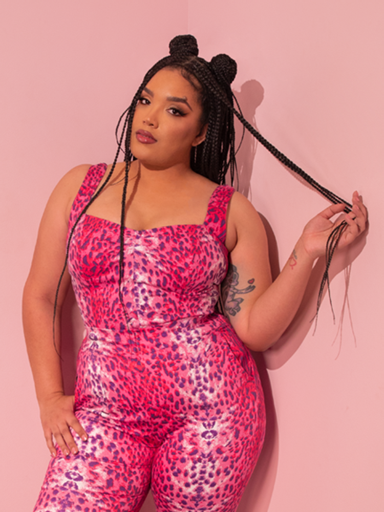 With a retro touch, a lovely female model captivates with her pose, showcasing the Pink Leopard Print Vamp Top from Vixen Clothing, a brand known for its vintage flair.