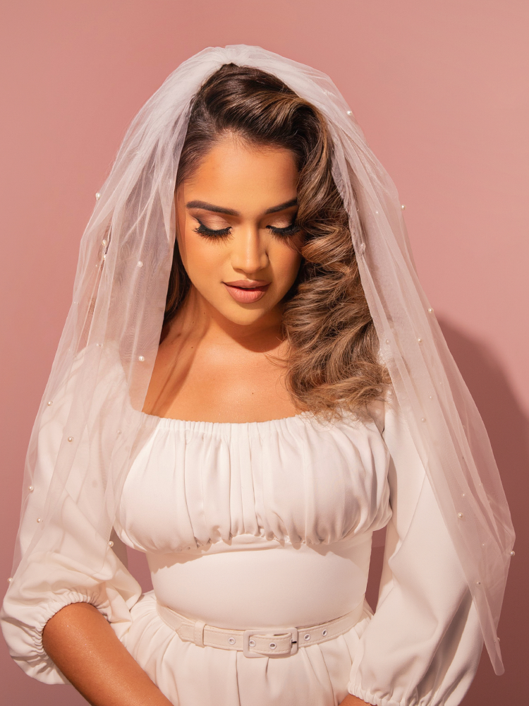Elevate your bridal look with this vintage-style tulle veil in white mesh, adorned with intricate pearl beadwork for a touch of timeless sophistication.