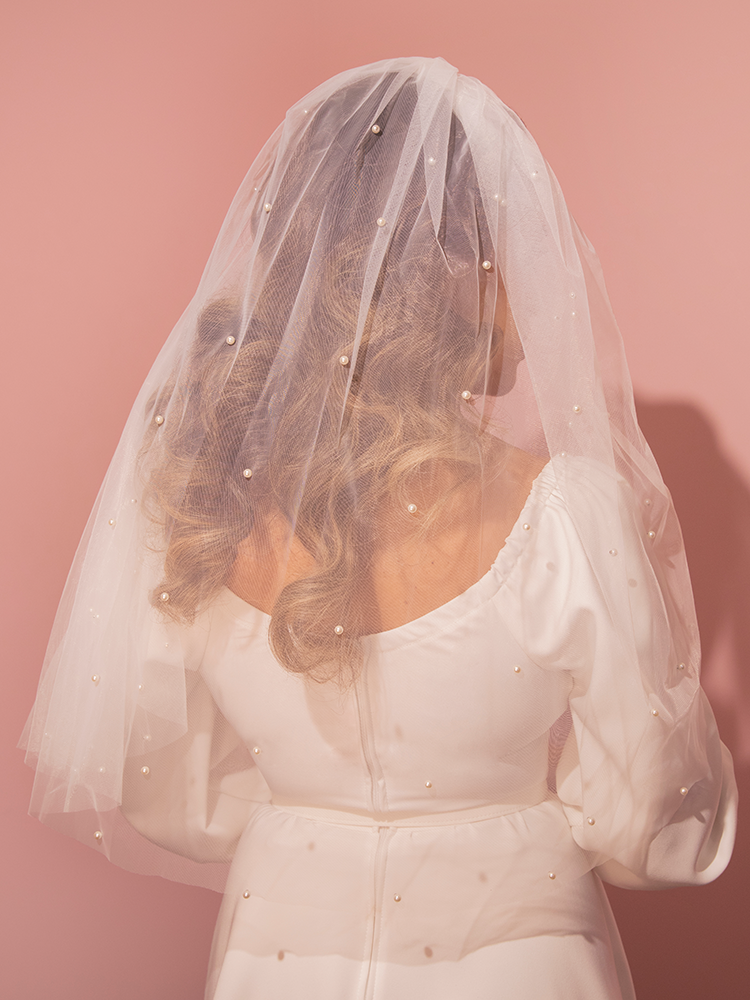 Step back in time with this classic Hollywood-inspired tulle veil, featuring elegant pearl bead accents on pristine white mesh, perfect for your retro wedding day.