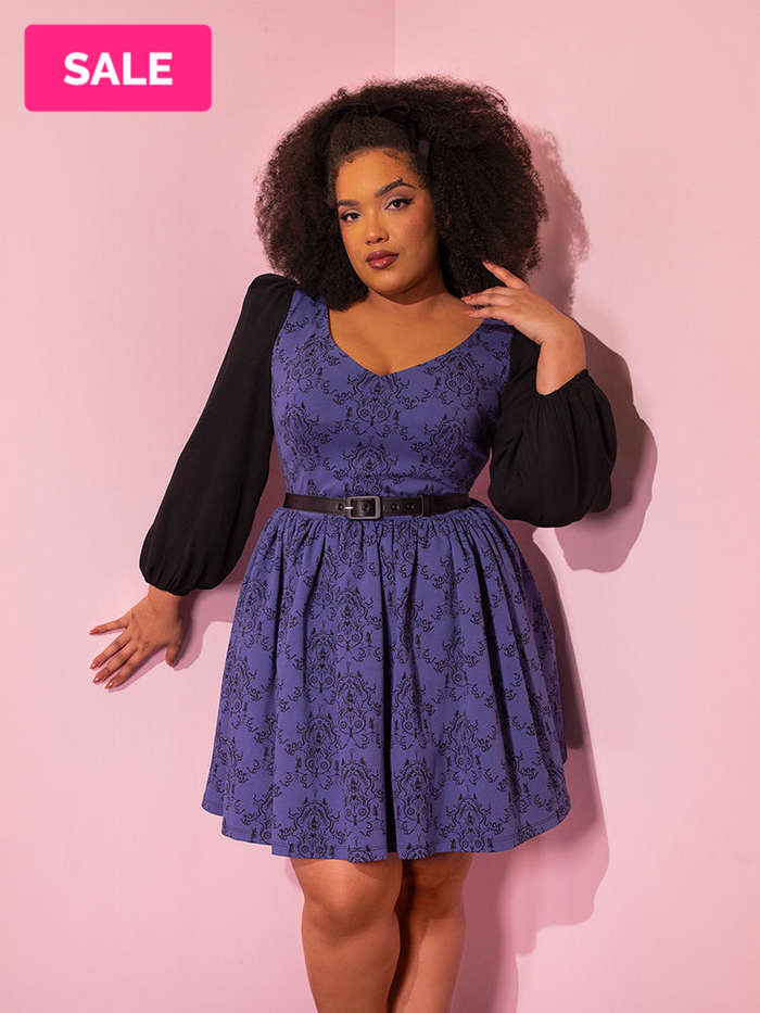 Model wearing a blue retro inspired dress from Vixen Clothing.