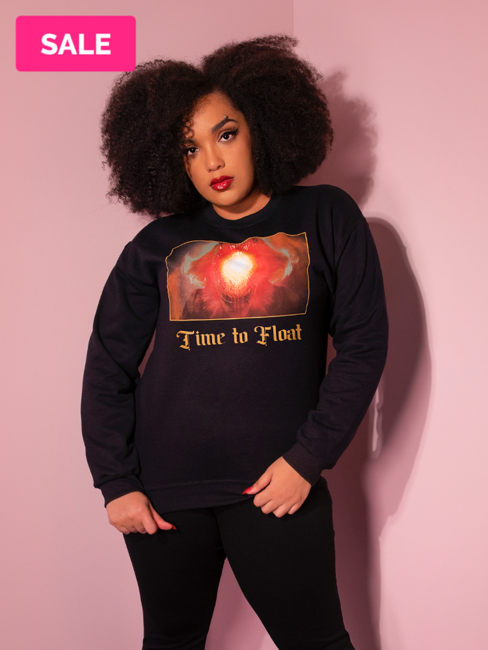 Looking at the camera, Ashleeta models the Time to Float Sweatshirt by Vixen Clothing.
