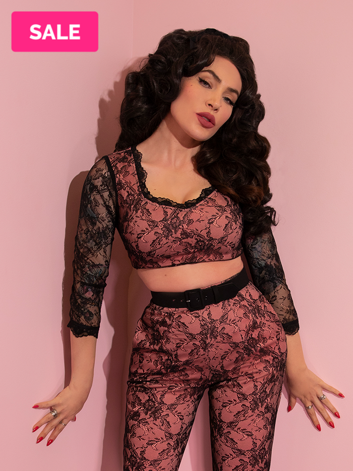 A closeup of Micheline Pitt modeling the Hollywood crop top in peach and black lace paired with matching pants.