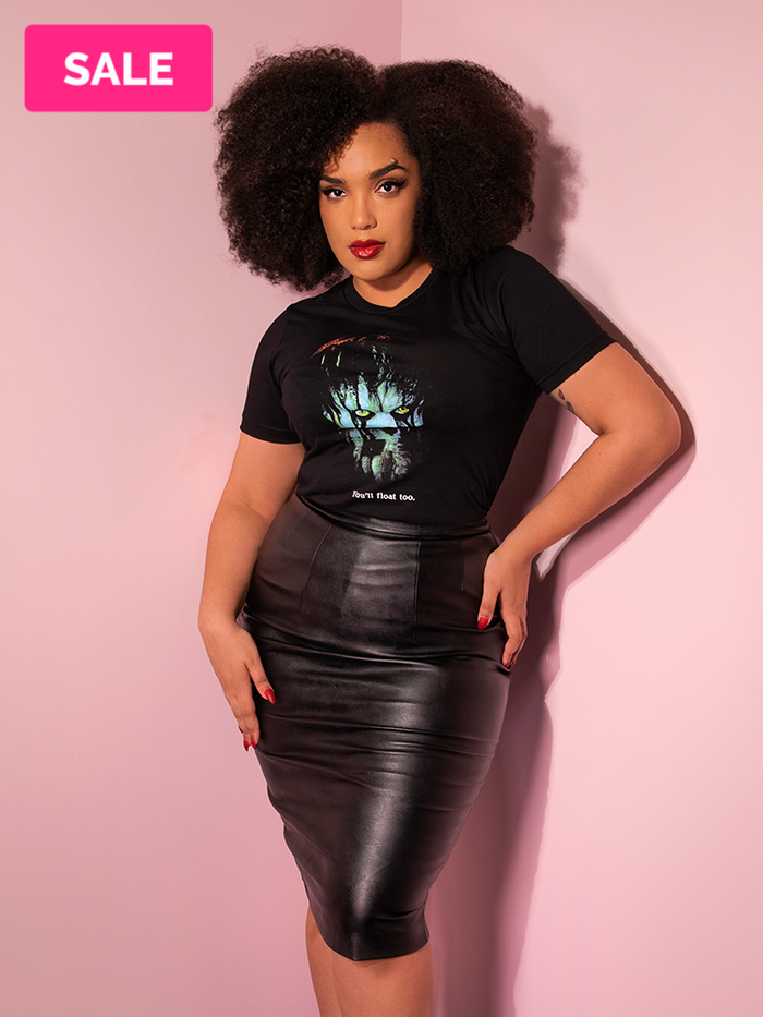 With her hands on her hips, Ashleeta shows off the Pennywise float tee by Vixen Clothing.