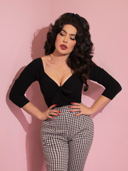 A closeup of Micheline Pitt modeling the tie me up top in black from Vixen Clothing paired with gingham pants.