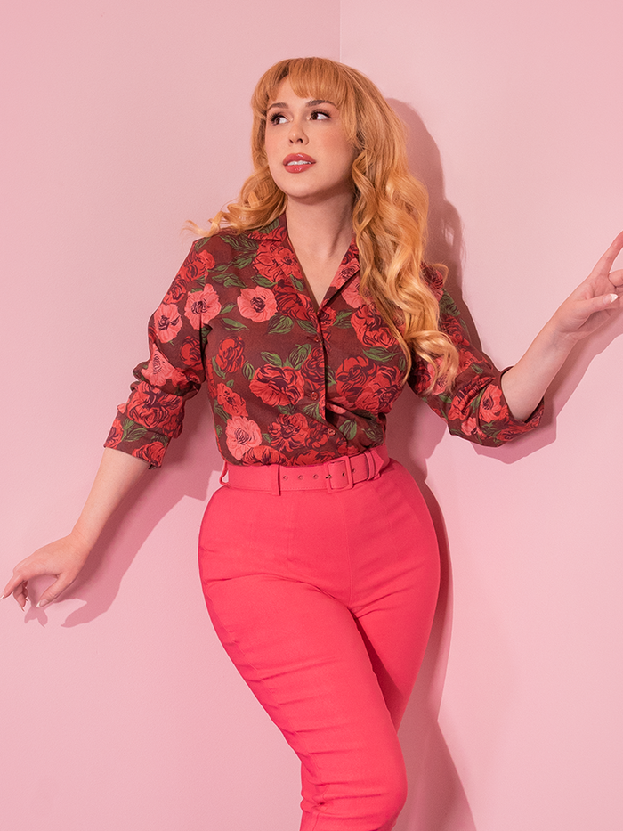 Model looking up while wearing a retro style outfit highlighted by the 1950's Vintage Style Button Up Blouse in Chocolate Roses.