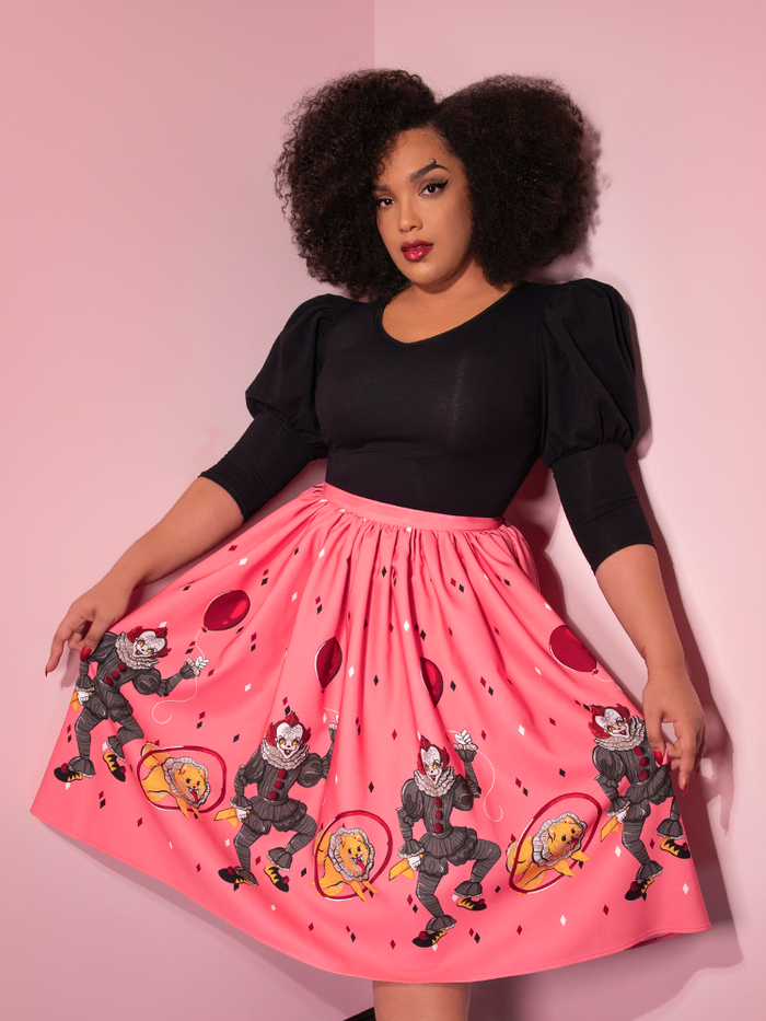 A closeup of Ashleeta modeling the Dancing Clown swing skirt in pink by Vixen Clothing.