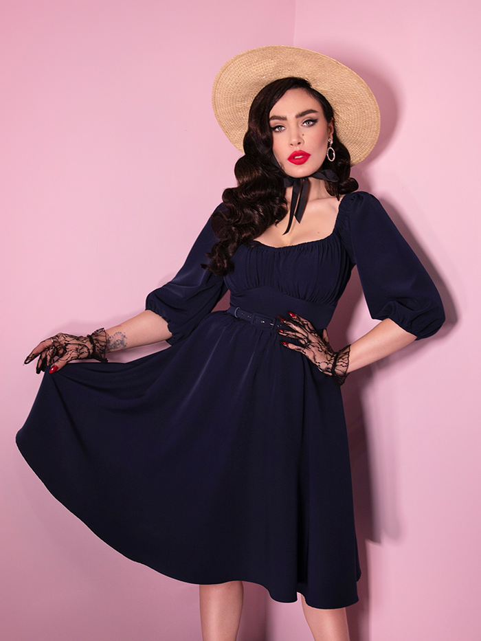 While wearing a natural colored sunhat, Micheline Pitt shows off the latest retro inspired dress from Vixen Clothing. Dubbed the "Vacation Dress in Navy Blue", it features all of the vintage stylings you've come to love from Vixen Clothing.