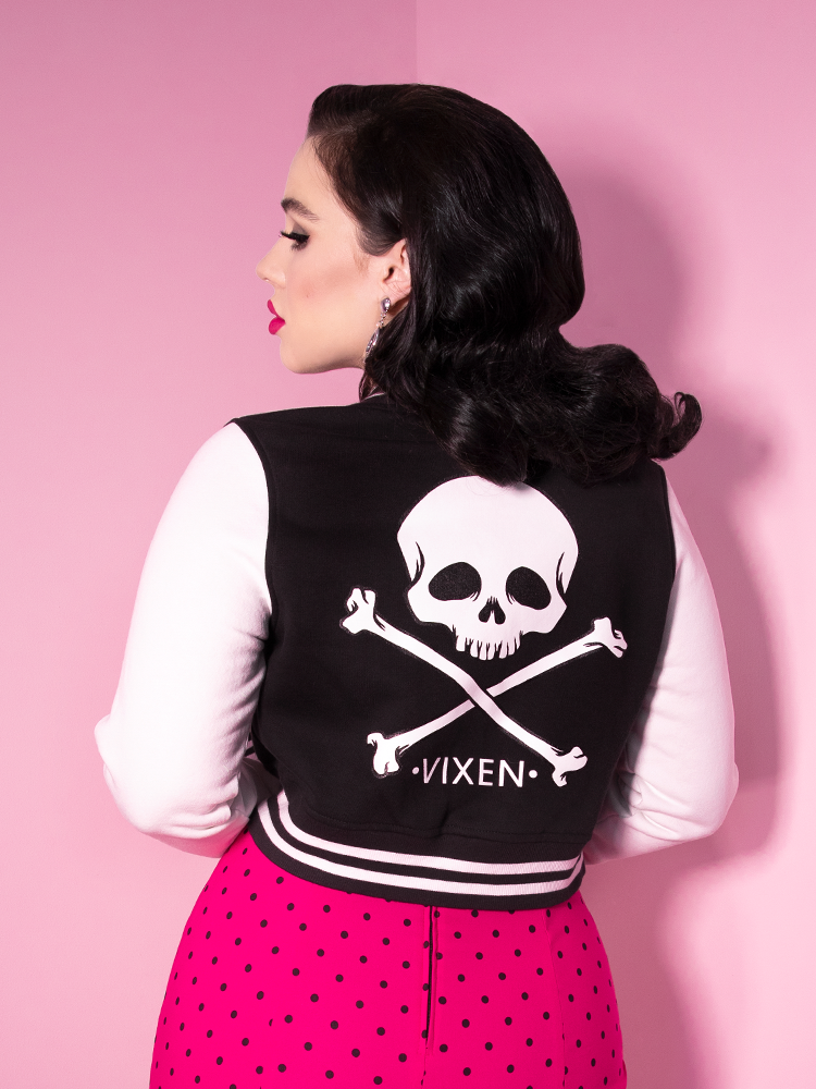 Vixen model Rachel Sedory showing off her Vixen Girl Gang Letterman Jacket along wtih a pink skirt with black polka dots.