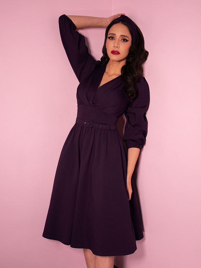 Milynn Moon wearing the Bawdy Swing Dress in Eggplant color from Vixen Clothing.