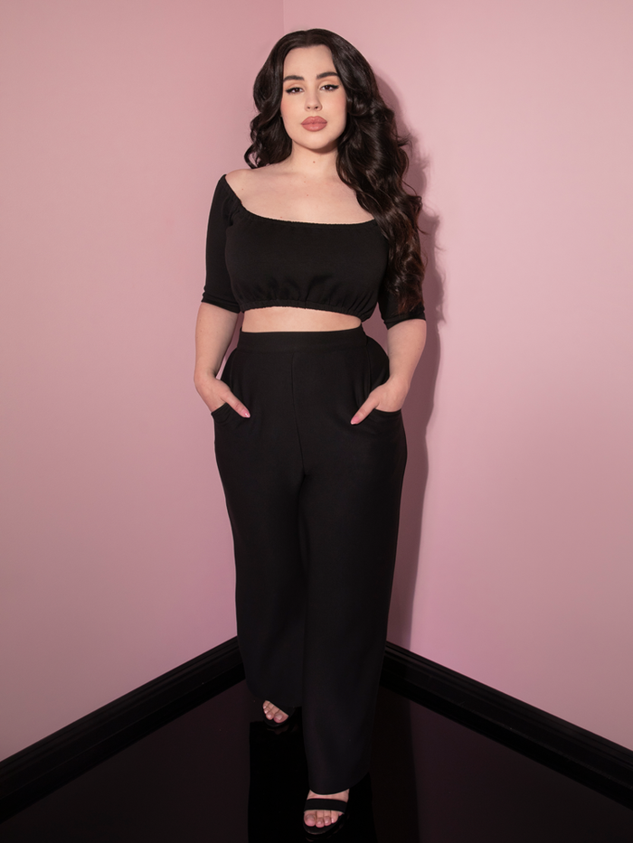 Rachel taking a step forward in the Cozy Lounge Pants in Black while wearing a matching black peasant style top.