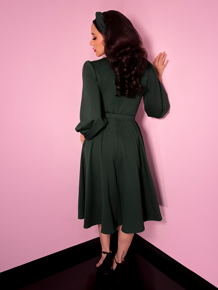 Milynn Moon showing off the back of the Bawdy Swing Dress in Hunter Green from retro dress maker Vixen Clothing.