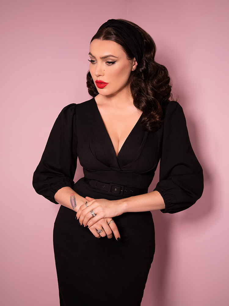 Close-up image of Micheline Pitt wearing the Bawdy Wiggle Dress in Black from Vixen Clothing, the finest retro dress and vintage clothing retailer.