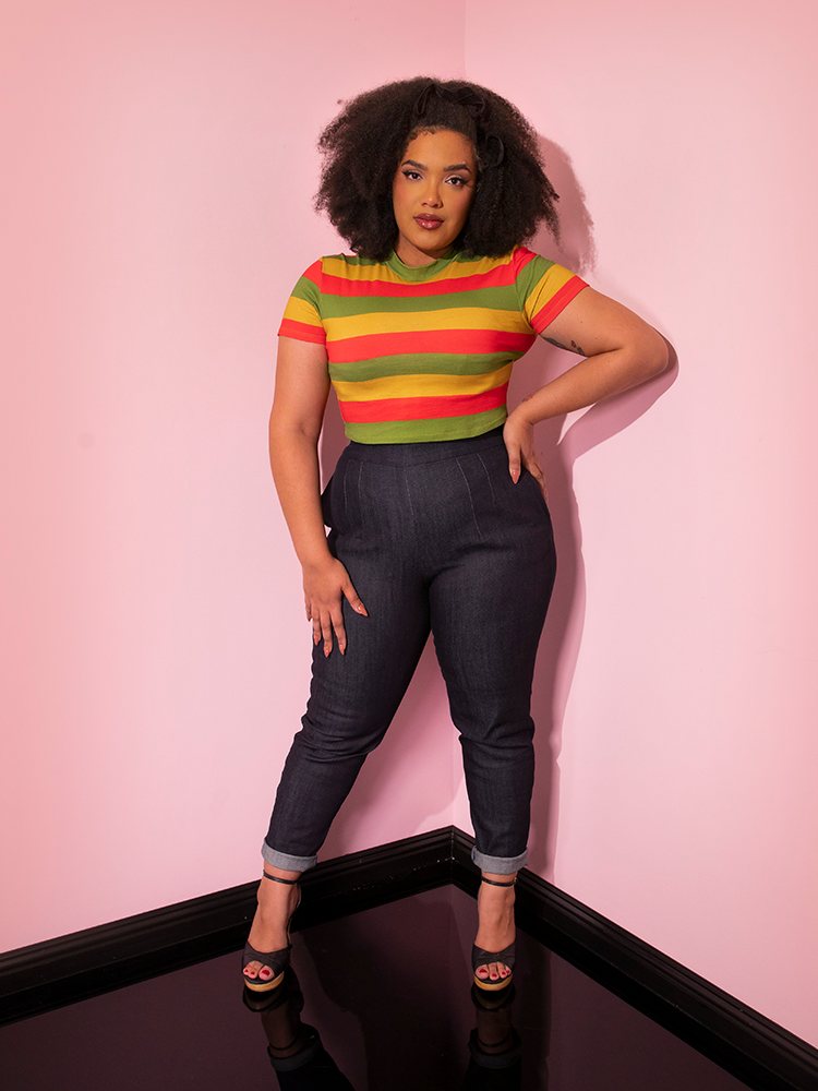 Full length shot of model posing in a retro style outfit including the Bad Girl Crop Top in Orange/Yellow/Avocado Stripes.