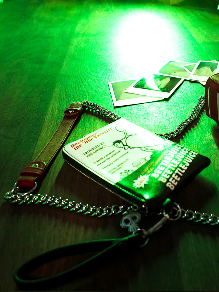 Isolated product shot of the BEETLEJUICE™ Bio-Exorcist Wristlet Wallet lit up in green lit.