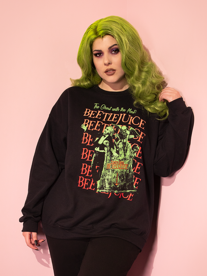 Green haired model wearing the Tombstone Sweatshirt from retro inspired clothing brand Vixen Clothing.