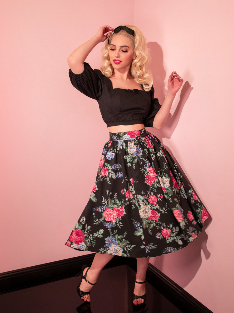 Model is caught swinging the skirt on the Vacation Swing Skirt in Black Rose Print.