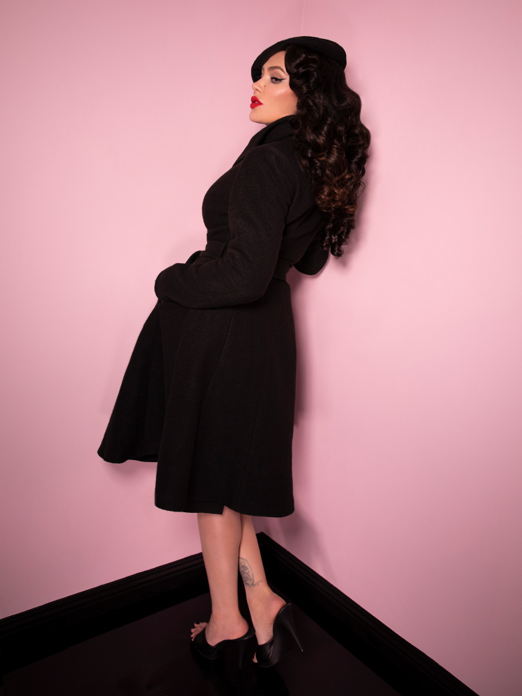 Side view of Micheline Pitt buttoned up in the Starlet Swing Coat in Black.