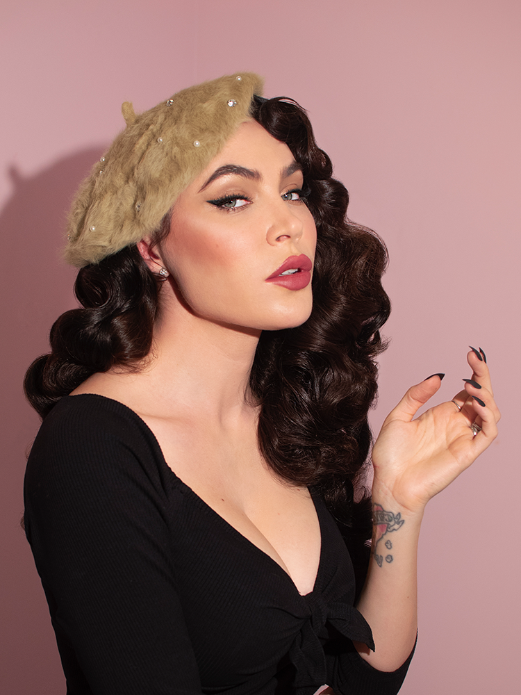A profile shot of Micheline Pitt modeling the Vintage Style Beret with Rhinestones in Pistachio Green from retro clothing company Vixen Clothing.