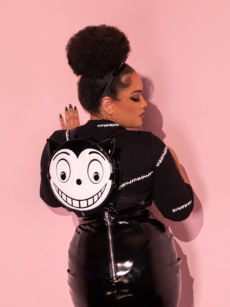 Ashleeta wearing the BATMAN RETURNS™ Catwoman Stitches Bad Girl Top with black vinyl skirt and CATWOMAN backpack.