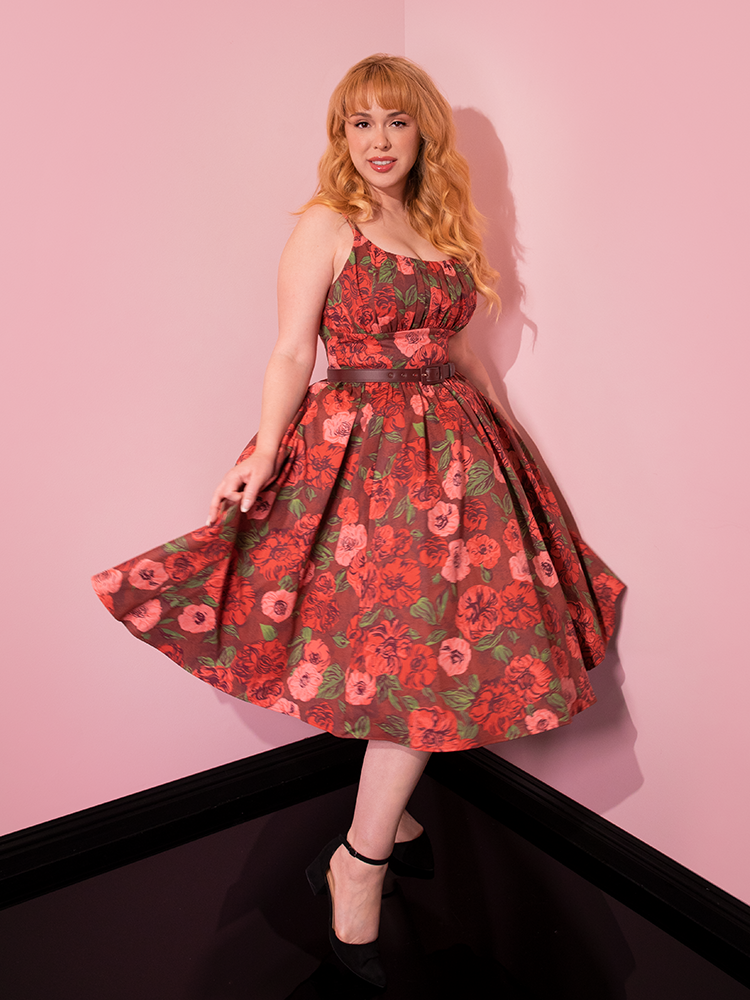 The Ingenue Dress in Chocolate Rose Print from Vixen Clothing is playfully modeled by beautiful retro-inspired figures, adding charm to the scene.
