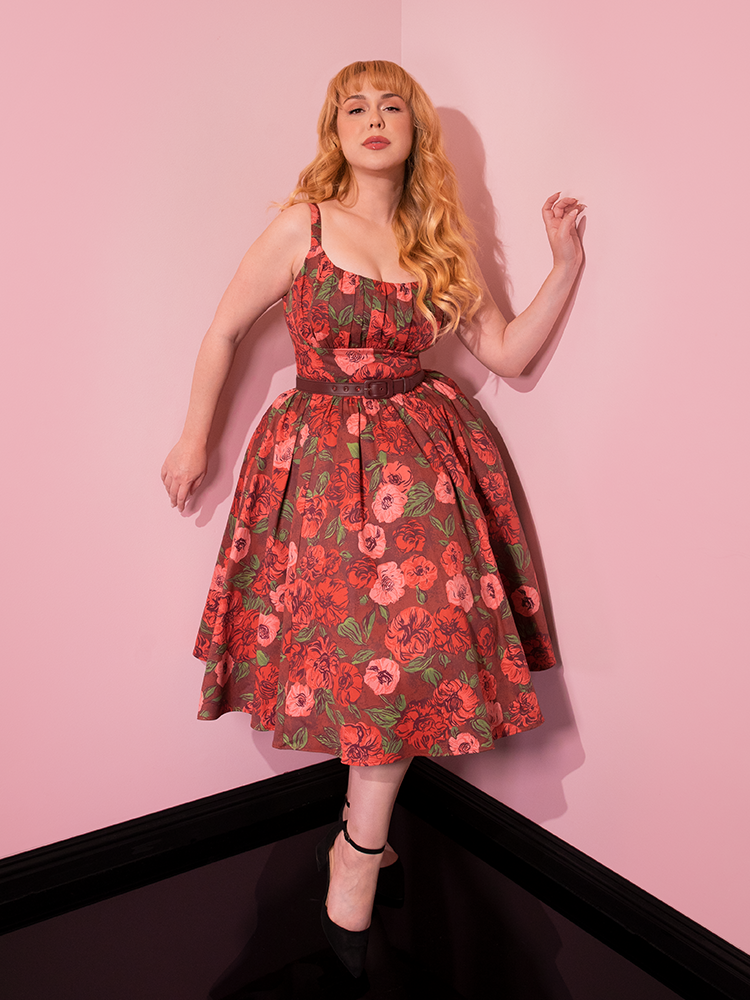 Playfully showcasing the retro spirit, beautiful models strike poses in the Chocolate Rose Print Ingenue Dress from the iconic retro dress brand Vixen Clothing.