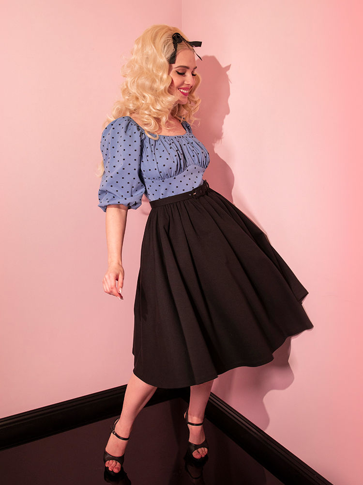 A smiling model wearing a retro style dress from Vixen Clothing.