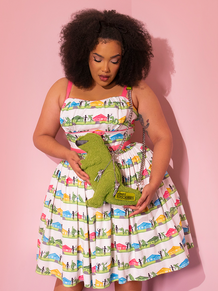 Ashleeta pairing the EDWARD SCISSORHANDS Vintage Sundress in Suburban Topiary Novelty Print with matching Dinosaur Hedge purse - all items from retro clothing company Vixen Clothing.