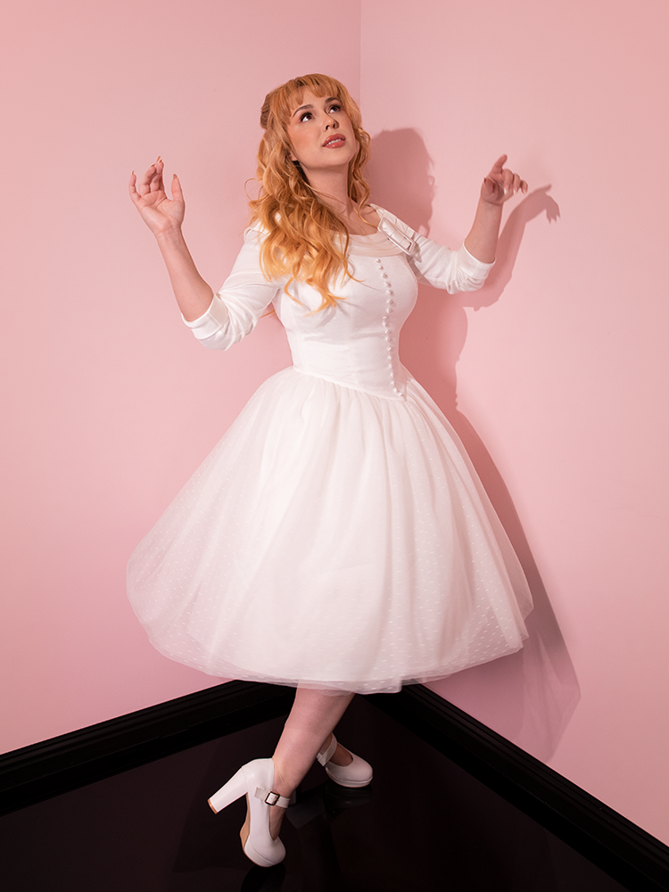 Female model looks upward while posing in the EDWARD SCISSORHANDS Ice Dance Dress With matching white platform shoes.